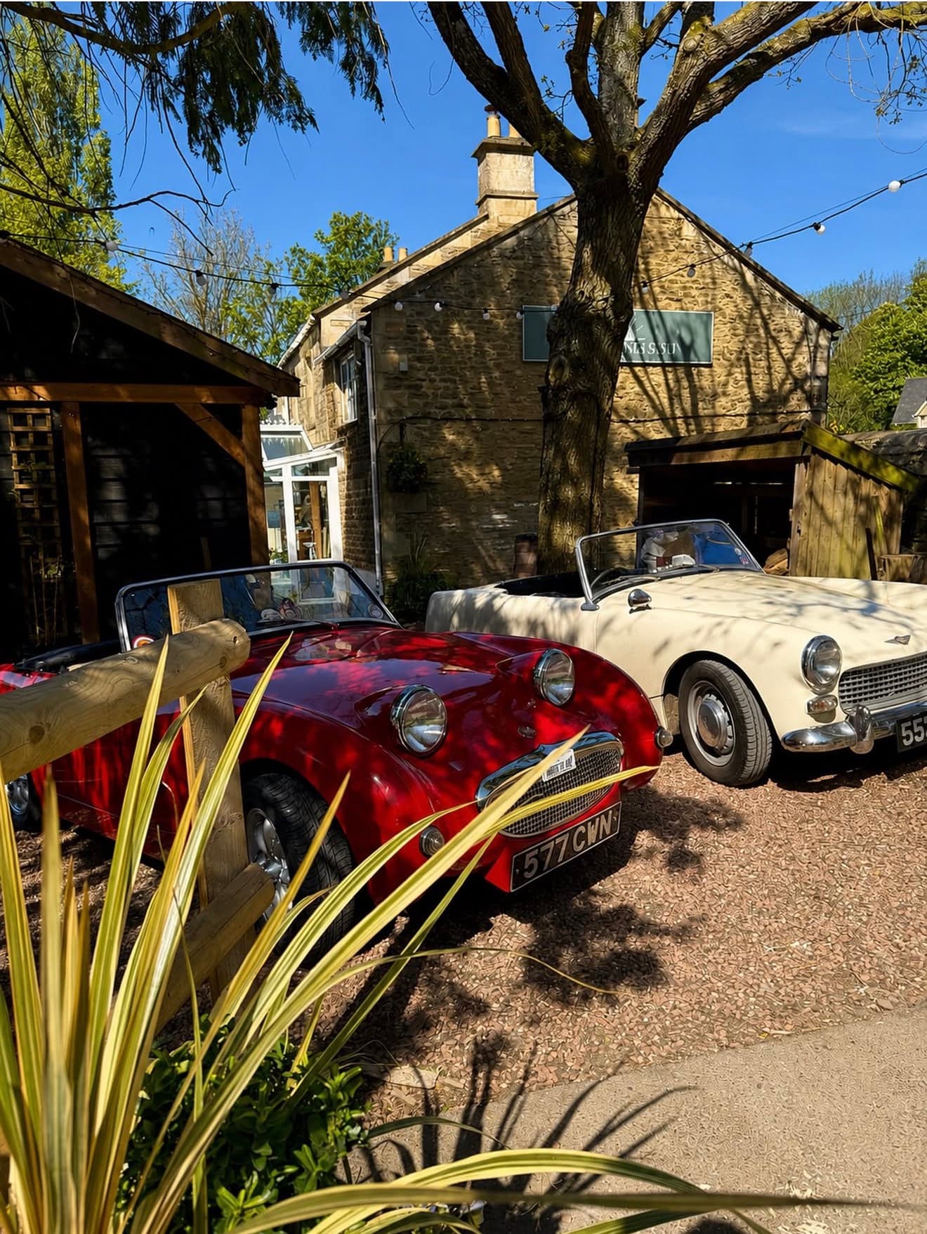 Red and cream classic cars outside The Rising Sun in Lacock at an earlier meet